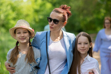 happy family-mother and two children daughter teen girls walking sunny summer day