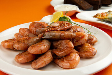 Fried shrimp in a plate on a yellow background.