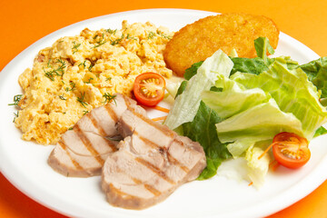 Traditional breakfast. Fried eggs, meat and hash brown in a plate.