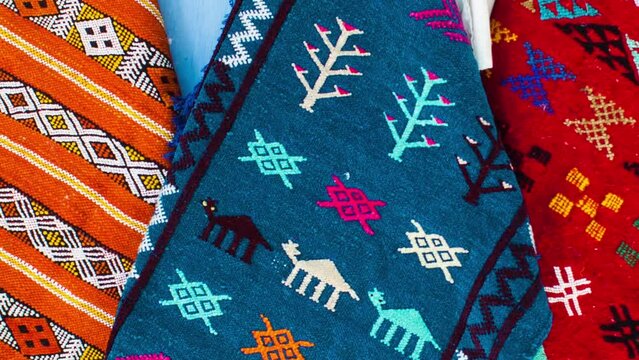 pan move shot of traditional handmade carpets in a craft market with different colors and patterns from Morocco