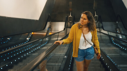 Woman using an escalator in metro.