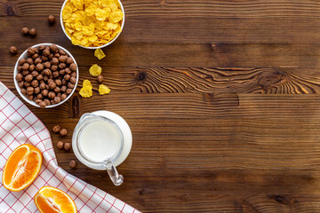 Bowls of corn flakes with milk and oranges for breakfast