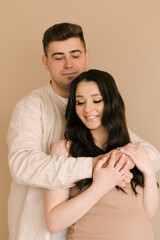 Fototapeta premium Young pregnant woman with husband at home, happy family and pregnancy concept
