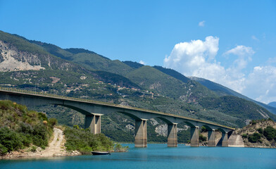 Fototapeta na wymiar Road Bridge Over Lake against mountain range