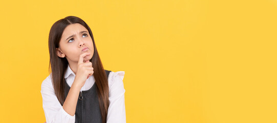 Imaginative girl child in school uniform keep thinking yellow background, imagination. Child face,...