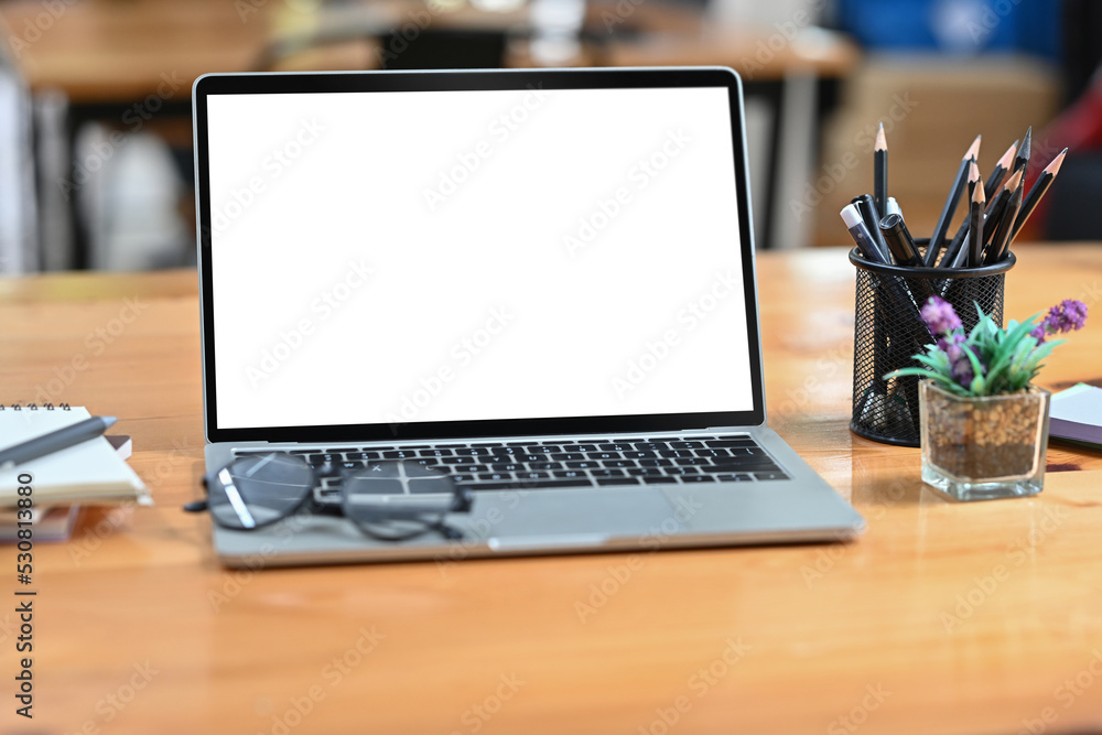 Aufkleber work space and co working space with empty screen of laptop placed on the desk.
