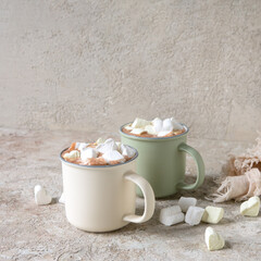 mugs with homemade cocoa with marshmallows on a light table, space for text