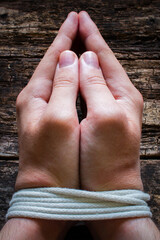 man slave prays with his hands tied