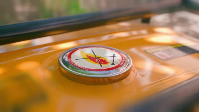 Filler cap of an orange gas tank close-up. Flammable hazardous material warning sticker. Crossed sign with match and fire. Fuel tank of benzene electric generator with blur. Smooth camera movement.