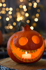 Smiling pumpkin, candle on dark background with bokeh Halloween.