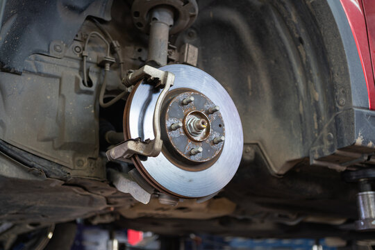 Cars whose wheels have been removed until the brake discs are visible