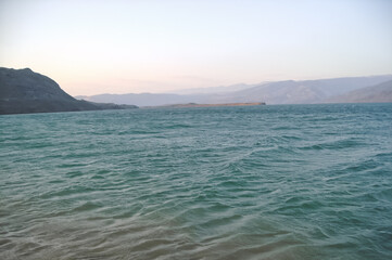 The blue water of the lake of the Chirkey reservoir in the early morning against the backdrop of a...