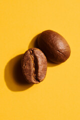 Roasted coffee beans on yellow background