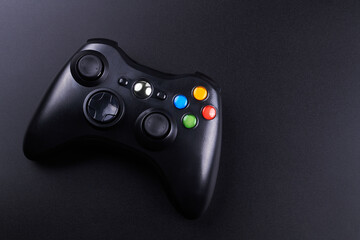 Black video game controller, joystick for game console isolated on black background. Gamer control device close-up