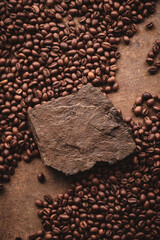 Roasted coffee beans on stone pedestal brown background