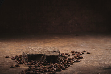 Roasted coffee beans on stone pedestal brown background