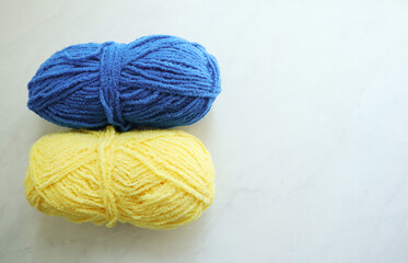 Fototapeta na wymiar Yellow and blue yarn balls on light background 