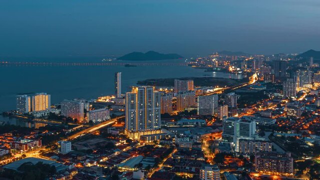 Panoramic view from the skyscraper to the city, bridge and sea bay on the evening in George Town, Penang, Malaysia. 4K time-lapse.