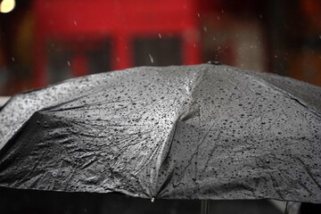 open black umbrella under heavy rain in chinatown new york city