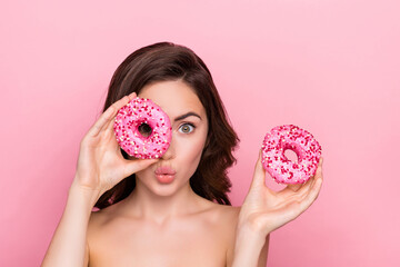 Photo of flirty funny young woman naked shoulders looking inside donut lips pouted isolated pink...