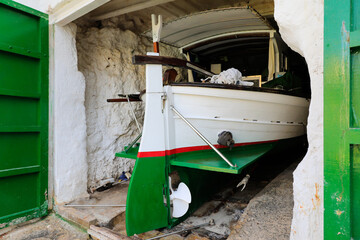 Fototapeta na wymiar Llaut mallorquín (típico barco de pesca de las Islas Baleares) en el interior de un embarcadero, llamado 