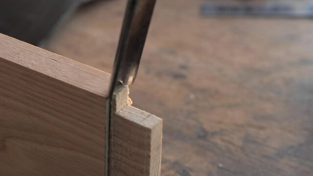 woodworker with chisel makes mortise and tenon 