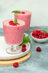 Yogurt smoothie with raspberries in glass on white marble table. weight loss concept. vertical image. place for text