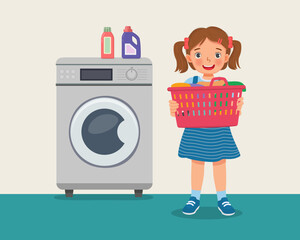 happy little girl holding basket full of clothes doing laundry daily chores with washing machine 