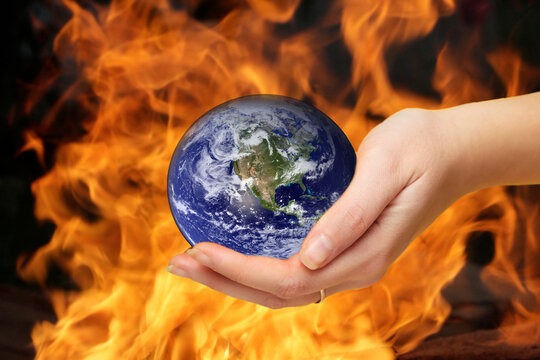 Defocus Female Hand Holding Planet Globe On Fire Flame Backgroun