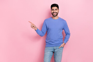 Photo of positive cheerful man direct finger empty space blank proposition isolated on pink color background