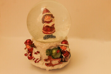 Obraz na płótnie Canvas winter girl figurine in a round glass ball with falling snow standing on standing on a white background Crystal Snow Globes Decorative Home Accessories
