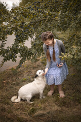 Photo of a beautiful girl with a dog near a plum tree.