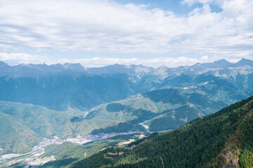 Fototapeta premium Alpine Meadows Trail, Krasnaya Polyana Resort. Alpine Meadows Walking Route. Aerial view of the green mountain valley, surrounded by high mountains.