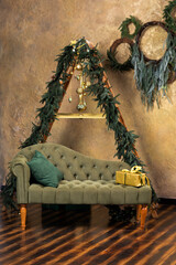 Fototapeta na wymiar Christmas composition with decoration, christmas tree branch, stylish green classic sofa, gift boxes and accessories in cozy home decor. Happy xmas and New Year holiday concept. Vertical photo