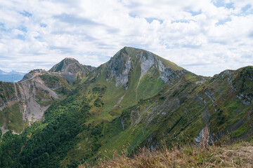 Alpine Meadows Trail, Krasnaya Polyana Resort. Alpine Meadows Walking Route. Aerial view of the green mountain valley, surrounded by high mountains.