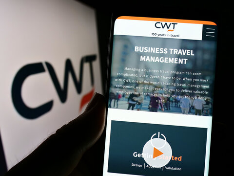 Stuttgart, Germany - 09-10-2022: Person holding cellphone with webpage of travel management company CWT Global B.V. on screen in front of logo. Focus on center of phone display.