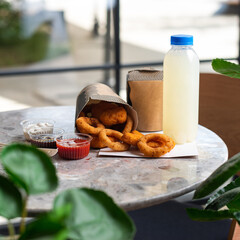 Crunchy deep fried squid or onion rings in batter set on gray stone table background. Co