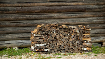 a small log with firewood near an old village house of the 19th century,