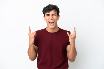 Young Argentinian man isolated on white background making horn gesture