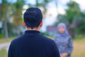 Groom is standing in front of his bride.