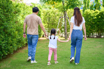 Naklejka na ściany i meble Happy Asian Family enjoying family walking time together in the park