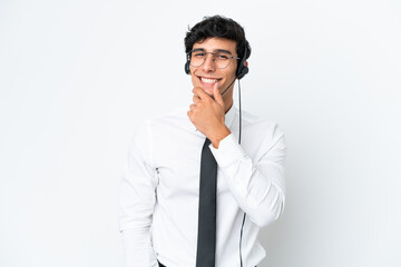 Telemarketer man working with a headset isolated on white background with glasses and smiling