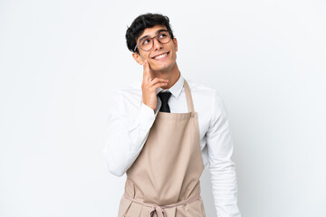 Restaurant Argentinian waiter isolated on white background thinking an idea while looking up