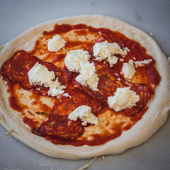 Italian pizza chef preparing and cooking pizza with mozzarella cheese tomato sauce and fresh basil leaf