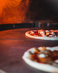 Italian pizza chef preparing and cooking pizza with mozzarella cheese tomato sauce and fresh basil leaf