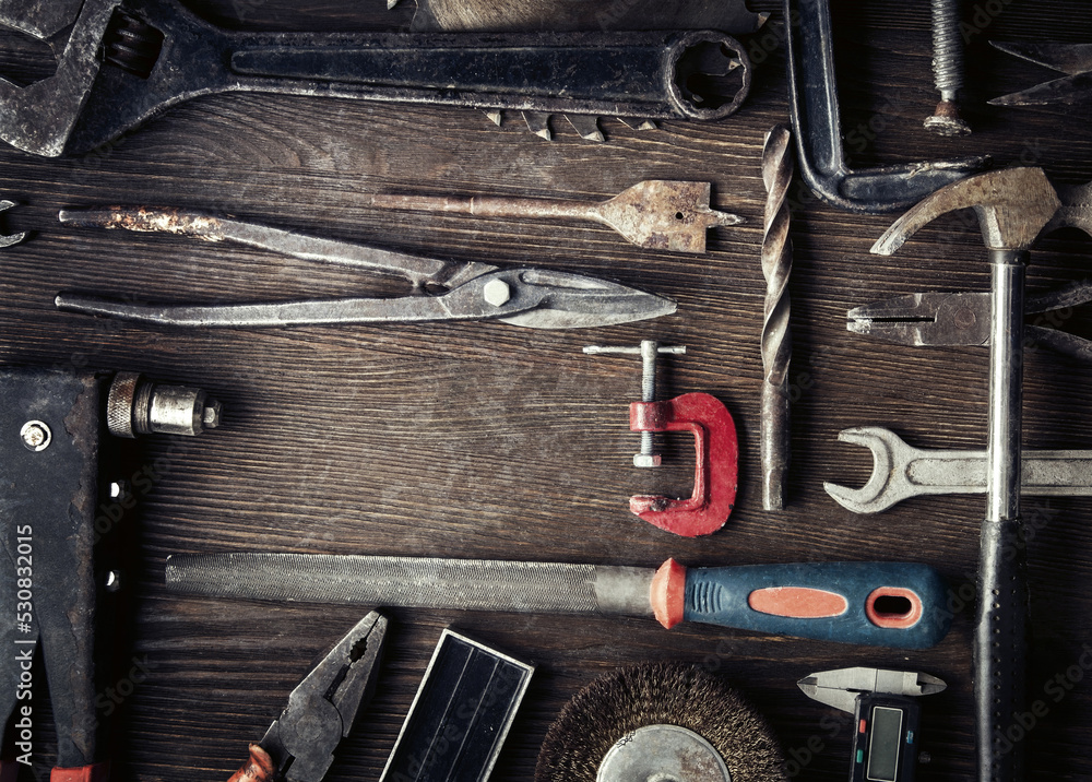 Wall mural grungy old tools on a wooden background (processing cross-process)