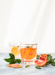Hard seltzer cocktail with blood orange. Cocktail or lemonade with fresh citrus. Refreshing drinks, low alcohol mocktail. Party concept. Shadow and sunlight.
