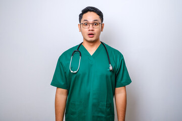Impressed and surprised asian male nurse or doctor in scrubs drop jaw and stare at camera...