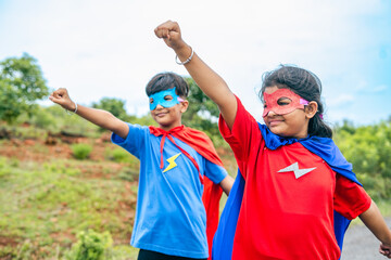 excited happy teenager kids in super hero costume on empty road with flying gesture - concept of fantasy, teamwork and courage. © WESTOCK