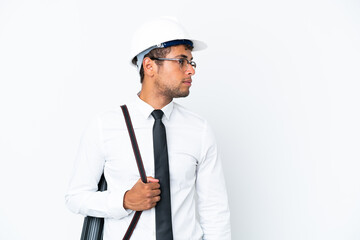 Architect brazilian man with helmet and holding blueprints looking to the side